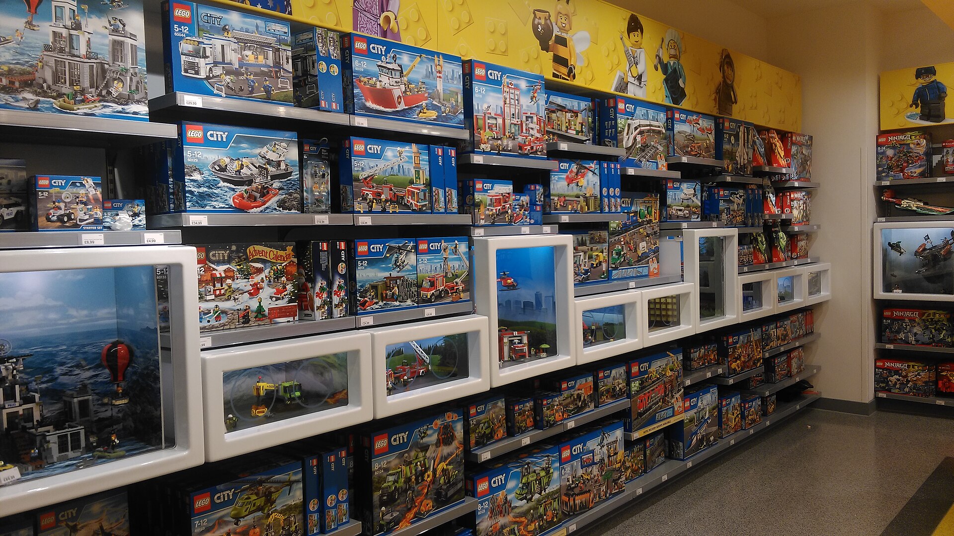 Boîtes de sets LEGO alignées sur les rayons d'un magasin, avec leurs étiquettes de prix